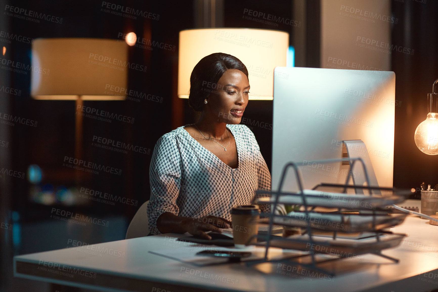 Buy stock photo Shot of a young businesswoman using a computer during a late night at work