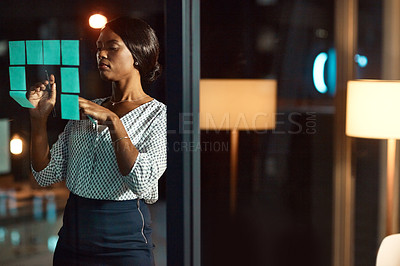 Buy stock photo Shot of a young businesswoman having a brainstorming session at night in a modern office