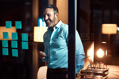 Buy stock photo Shot of a mature businessman having a brainstorming session at night in a modern office