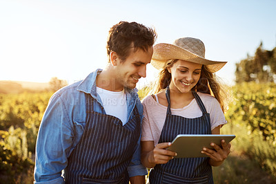 Buy stock photo Cropped shot of an affectionate young couple using a digital tablet together on a farm