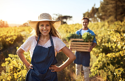 Buy stock photo Cropped portrait of an attractive young woman working on a farm with a male colleague in the background