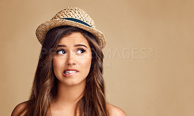 Buy stock photo Studio shot of a beautiful young woman looking thoughtful against a brown background