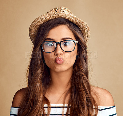 Buy stock photo Studio shot of a beautiful young woman pouting against a brown background