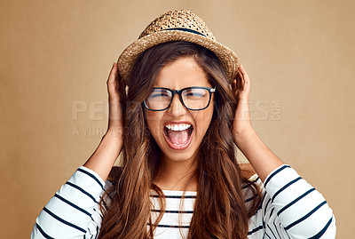 Buy stock photo Studio portrait of an attractive young woman screaming against a gray background