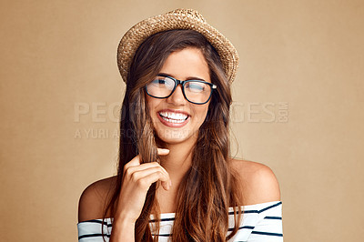 Buy stock photo Studio shot of a beautiful young woman smiling against a brown background