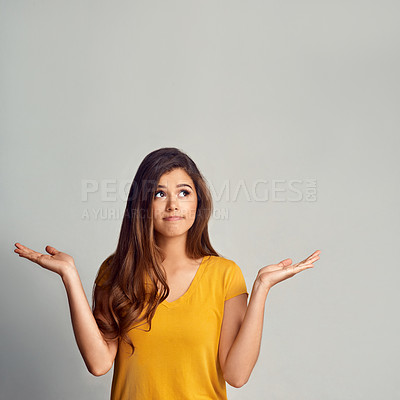 Buy stock photo Studio shot of an attractive young woman showing copyspace against a grey background