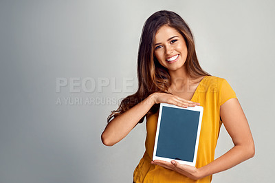 Buy stock photo Studio portrait of an attractive young woman holding a digital tablet with a blank screen against a grey background