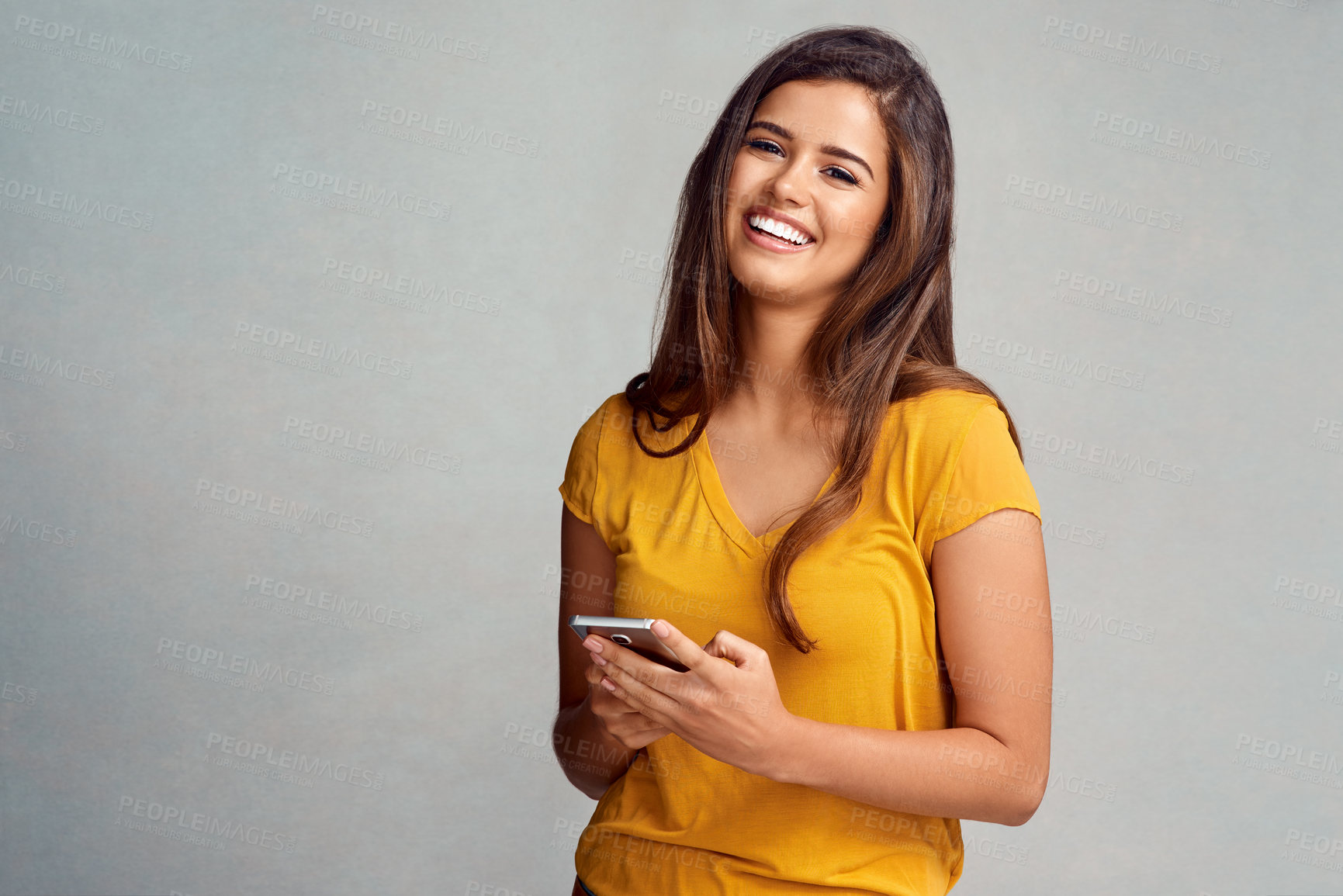 Buy stock photo Woman, smile and portrait with smartphone in studio background for social media, networking and online dating. Female person, happy and satisfied with good news, streaming platform and entertainment