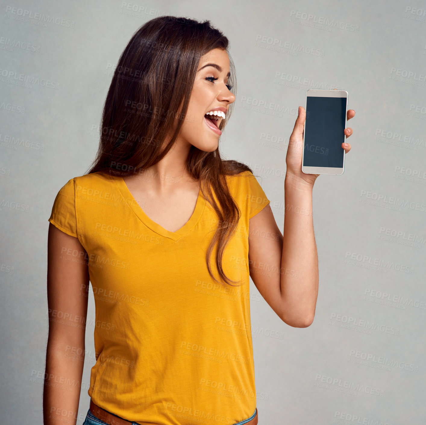 Buy stock photo Surprise, woman and display of phone in studio with mockup space for advertising, marketing or promotion. Wow, technology and female person presenting cellphone screen isolated by gray background.