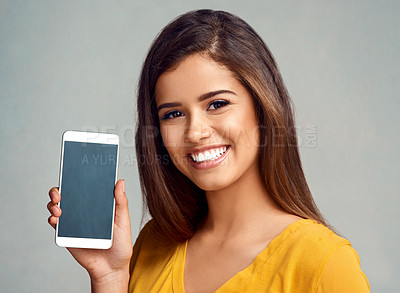 Buy stock photo Happy, woman and display of cellphone in studio with mockup space for advertising, marketing or promotion. Portrait, technology and female person presenting phone screen isolated by gray background.