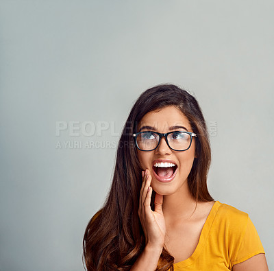 Buy stock photo Studio shot of an attractive young woman looking thoughtful against a grey background