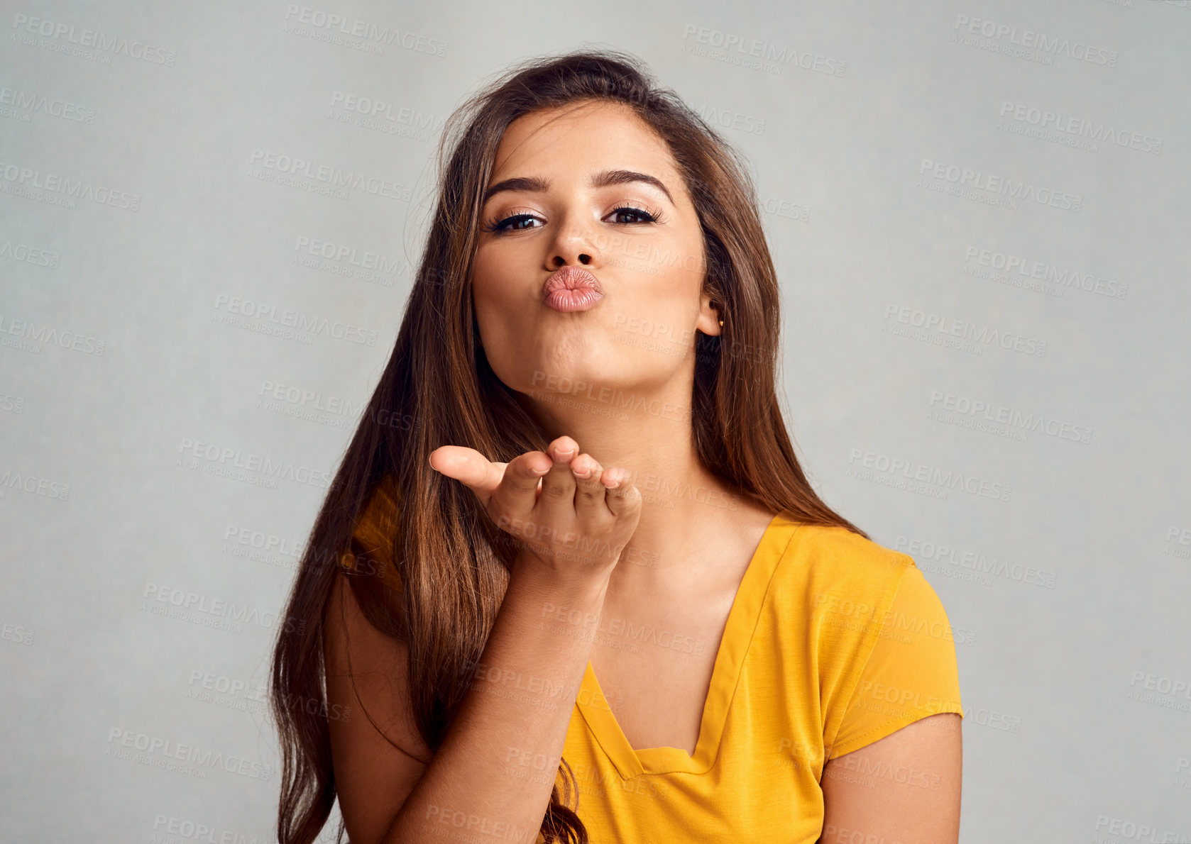 Buy stock photo Studio, portrait and woman with blow for kiss, flirting and playful with affection gesture for goodbye. Female model, pout and emoji reaction by gray background for romance, face expression and love