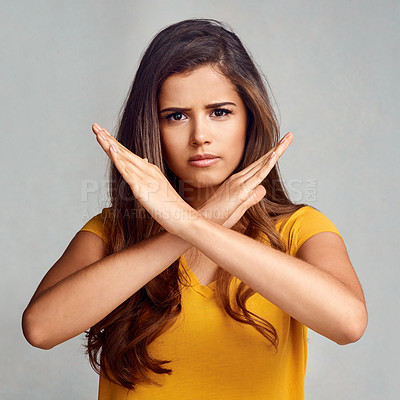 Buy stock photo Studio portrait of an attractive young woman posing with her hands crossed against a grey background