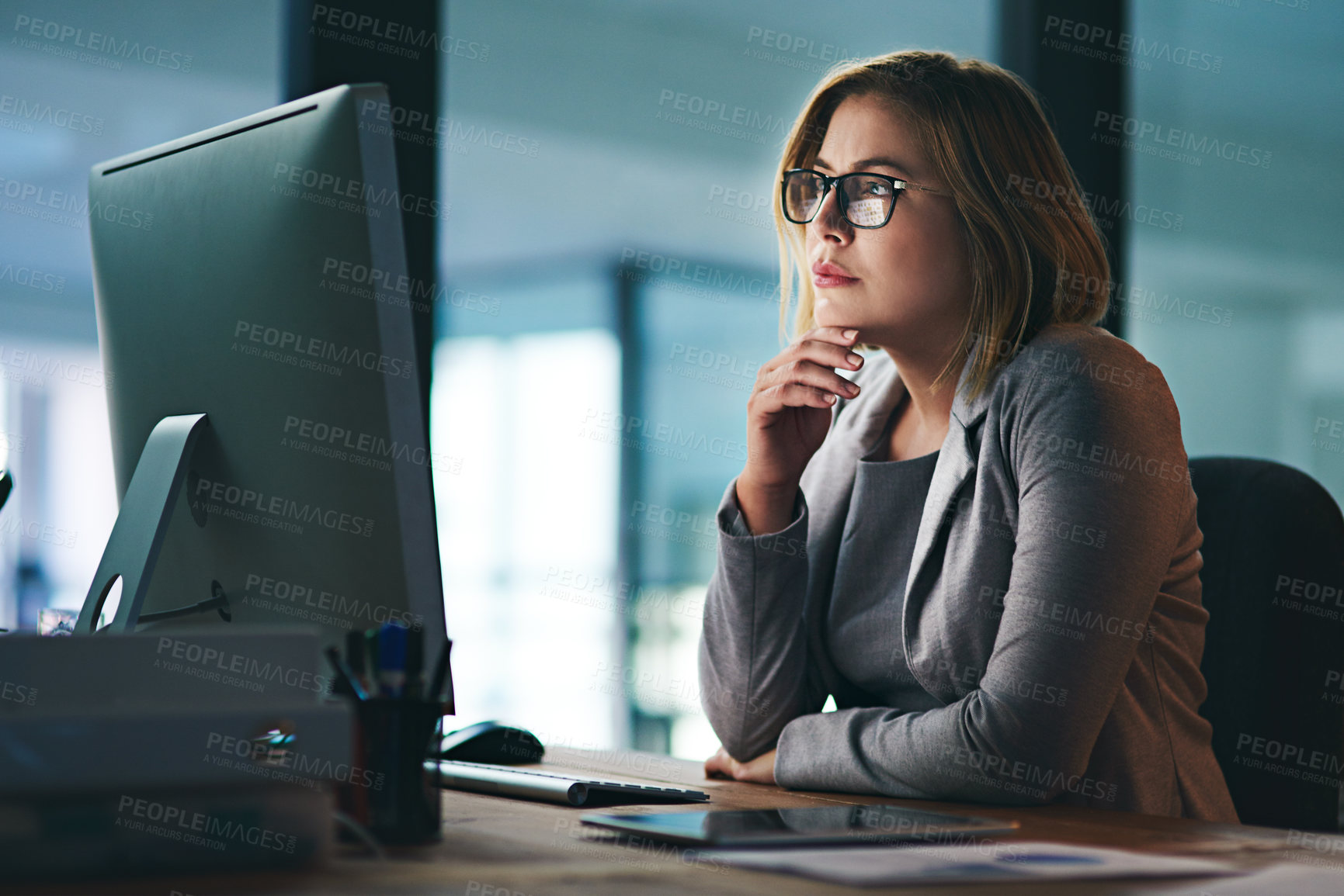 Buy stock photo Shot of a young businesswoman working late on a computer in an office