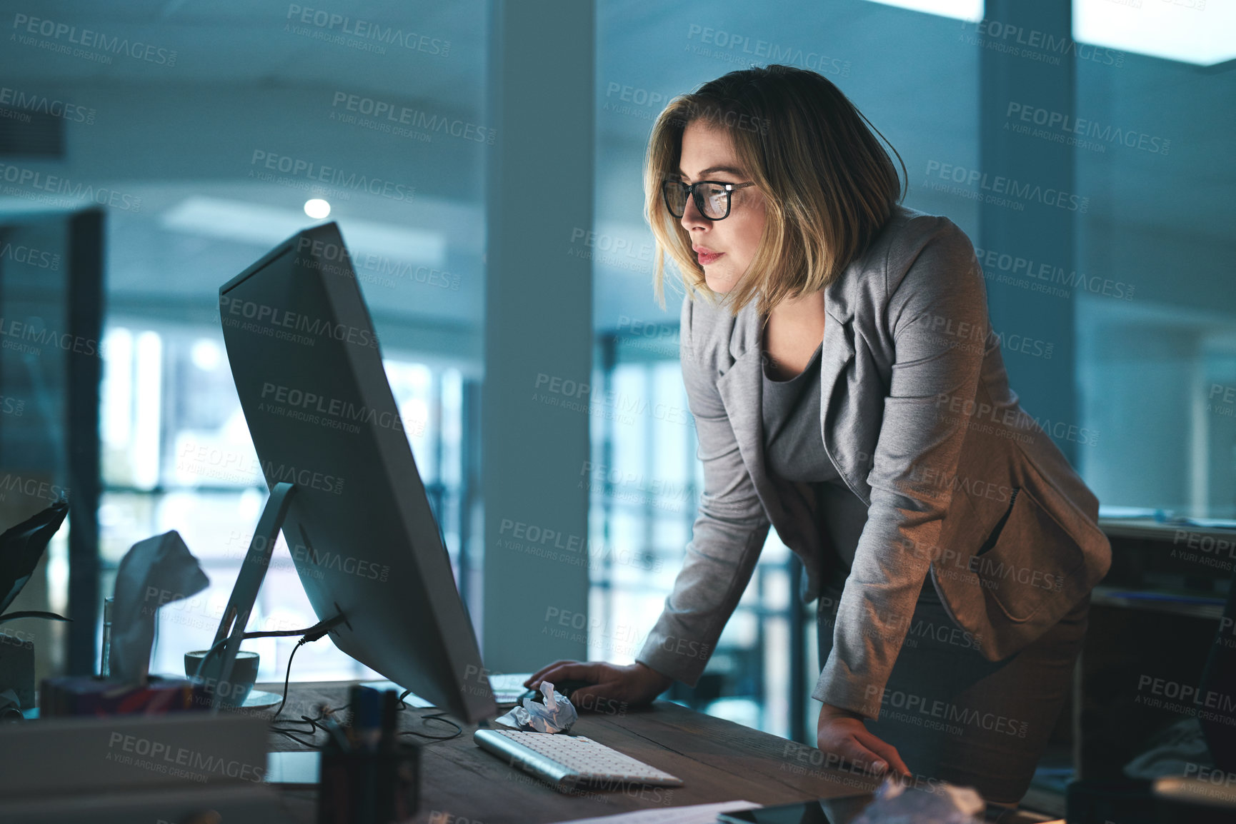 Buy stock photo Woman, employee and reading on computer in office on browsing internet, online and research for ideas. Female person, workplace and desk with deadline or overtime, project and standing as hr