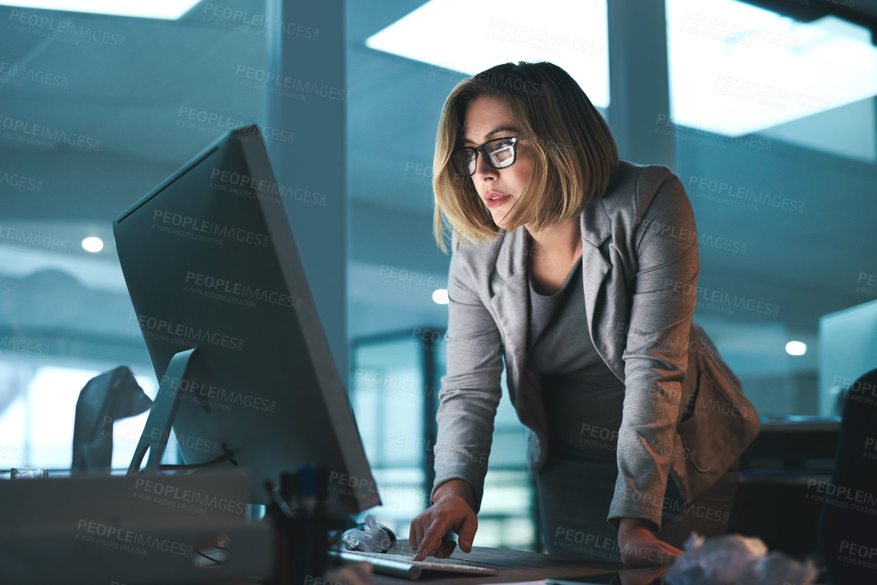 Buy stock photo Woman, employee and standing on computer in office on browsing internet, online and research for ideas. Female person, workplace and desk with deadline or overtime, project and reading as hr