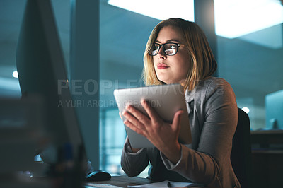 Buy stock photo Shot of a young businesswoman working late on a digital tablet in an office