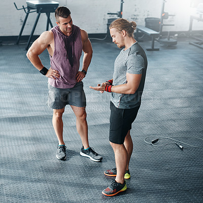 Buy stock photo Shot of two young men chatting at the gym