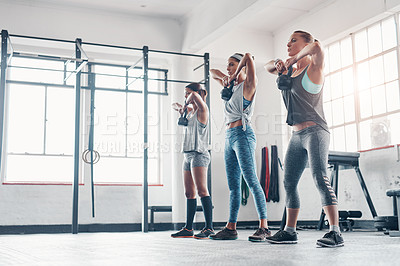 Buy stock photo Shot of three women working out with weights at the gym