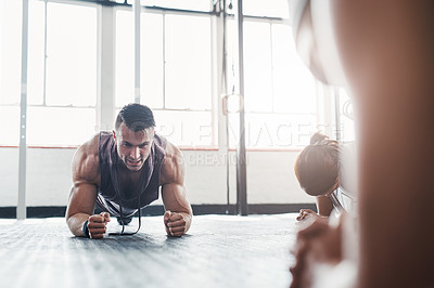 Buy stock photo Shot of a determined young man doing pushups at the gym