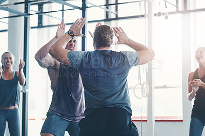 Buy stock photo Shot of a fitness group celebrating a victory at the gym