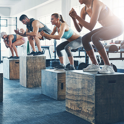 Buy stock photo Shot of a fitness group box jumping at the gym