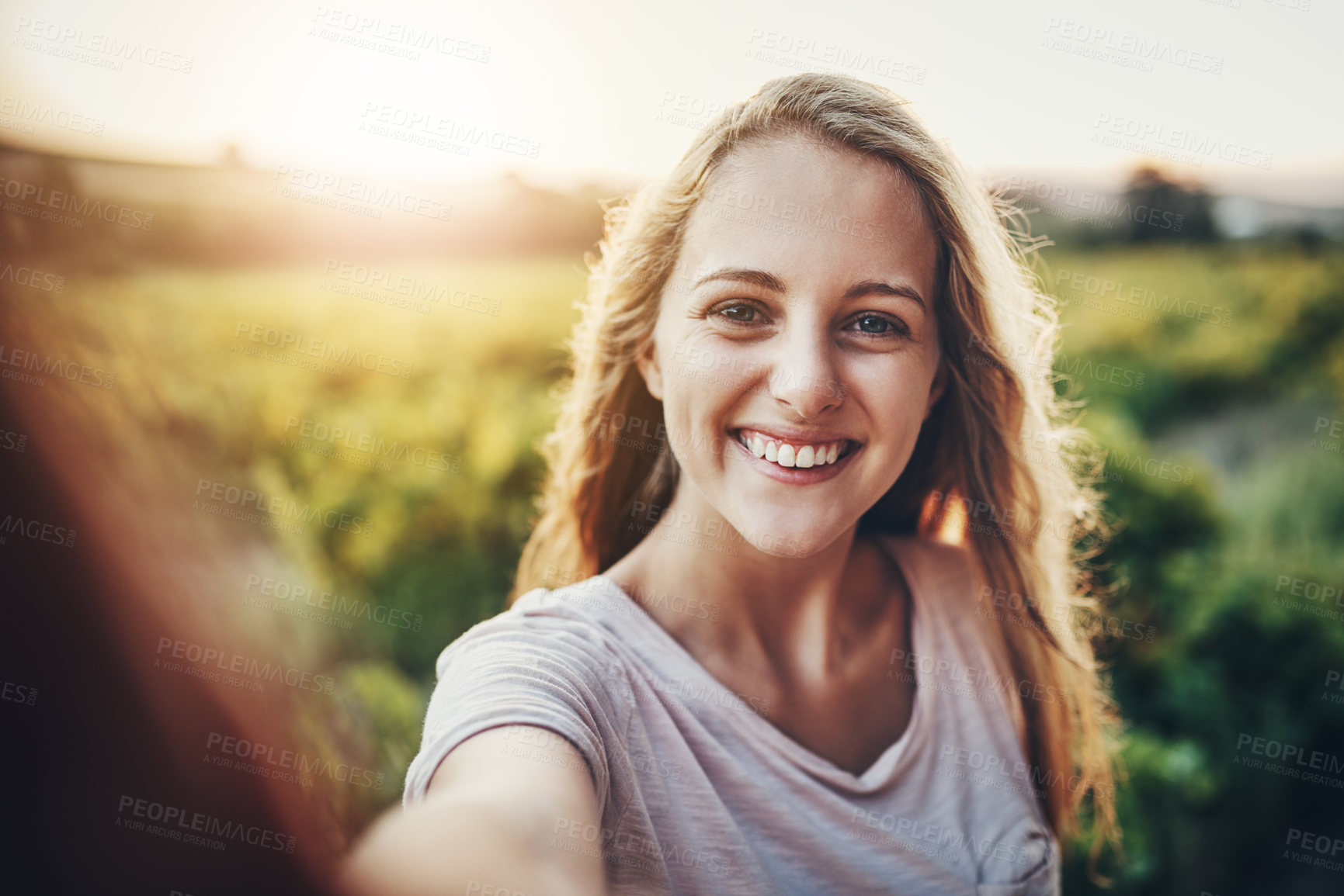 Buy stock photo Cropped portrait of a happy young woman taking a photo of herself and her farm in the background