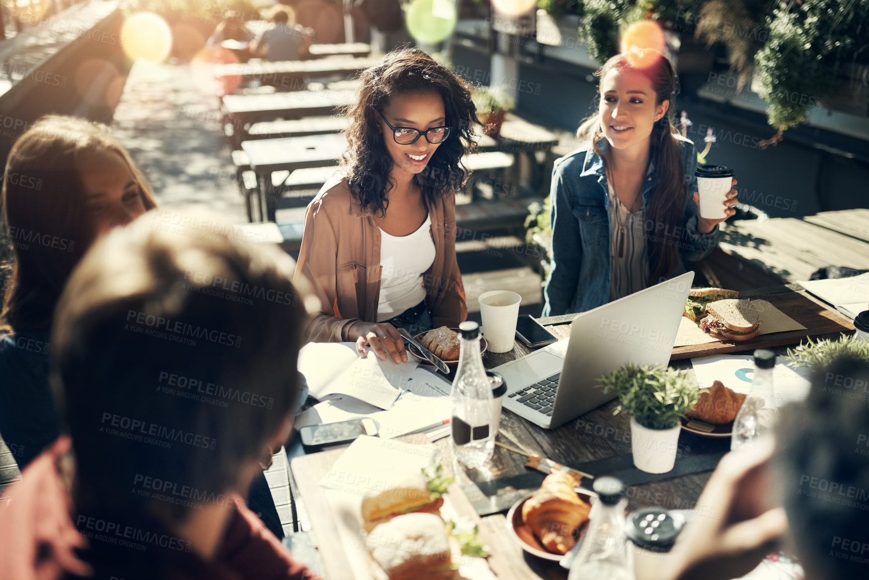 Buy stock photo High angle shot of a group of creative employees having a breakfast meeting outside