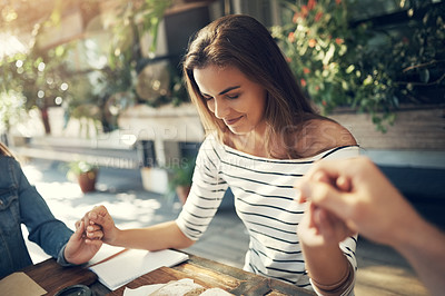 Buy stock photo Cropped shot of a group of creative employees holding hands and praying before breakfast outdoors