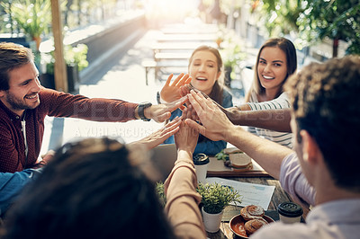 Buy stock photo High angle shot of a group of creative workers high fiving while out on a business lunch