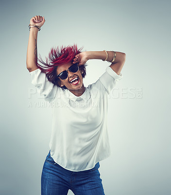 Buy stock photo Shot of a beautiful young woman wearing sunglasses against a grey background