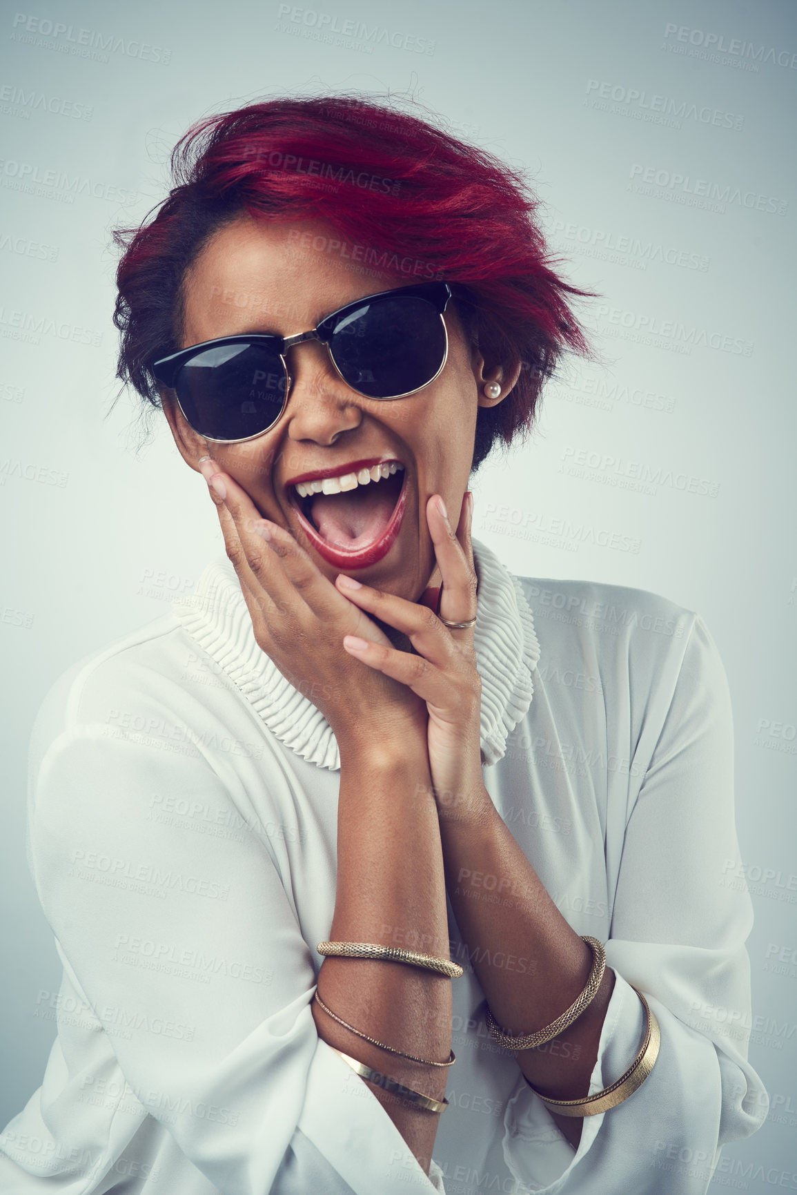 Buy stock photo Shot of a beautiful young woman wearing sunglasses against a grey background