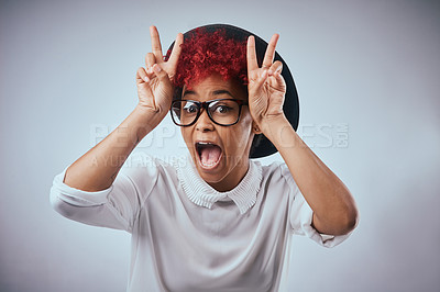 Buy stock photo Studio shot of a beautiful young woman being silly against a grey background