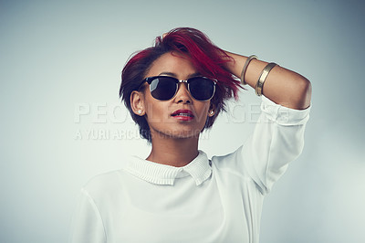 Buy stock photo Shot of a beautiful young woman wearing sunglasses against a grey background