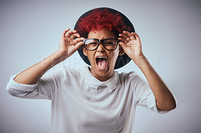 Buy stock photo African woman, shout and portrait with fashion and hipster style with yelling and angry emoji gesture. Studio, glasses and trendy eyewear with minimalist outfit and hip clothes with grey background