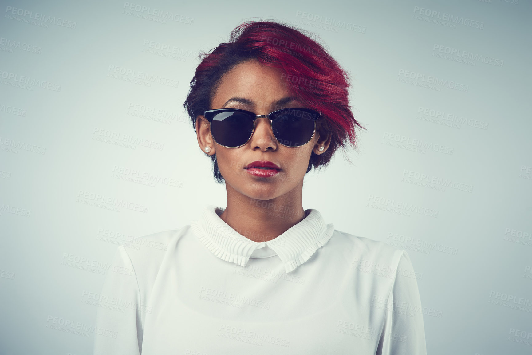 Buy stock photo Woman, portrait and sunglasses in studio for fashion, designer wear and stylish accessory. Girl, red hair and brand shades on gray background with confidence, attitude and lip cosmetics for aesthetic