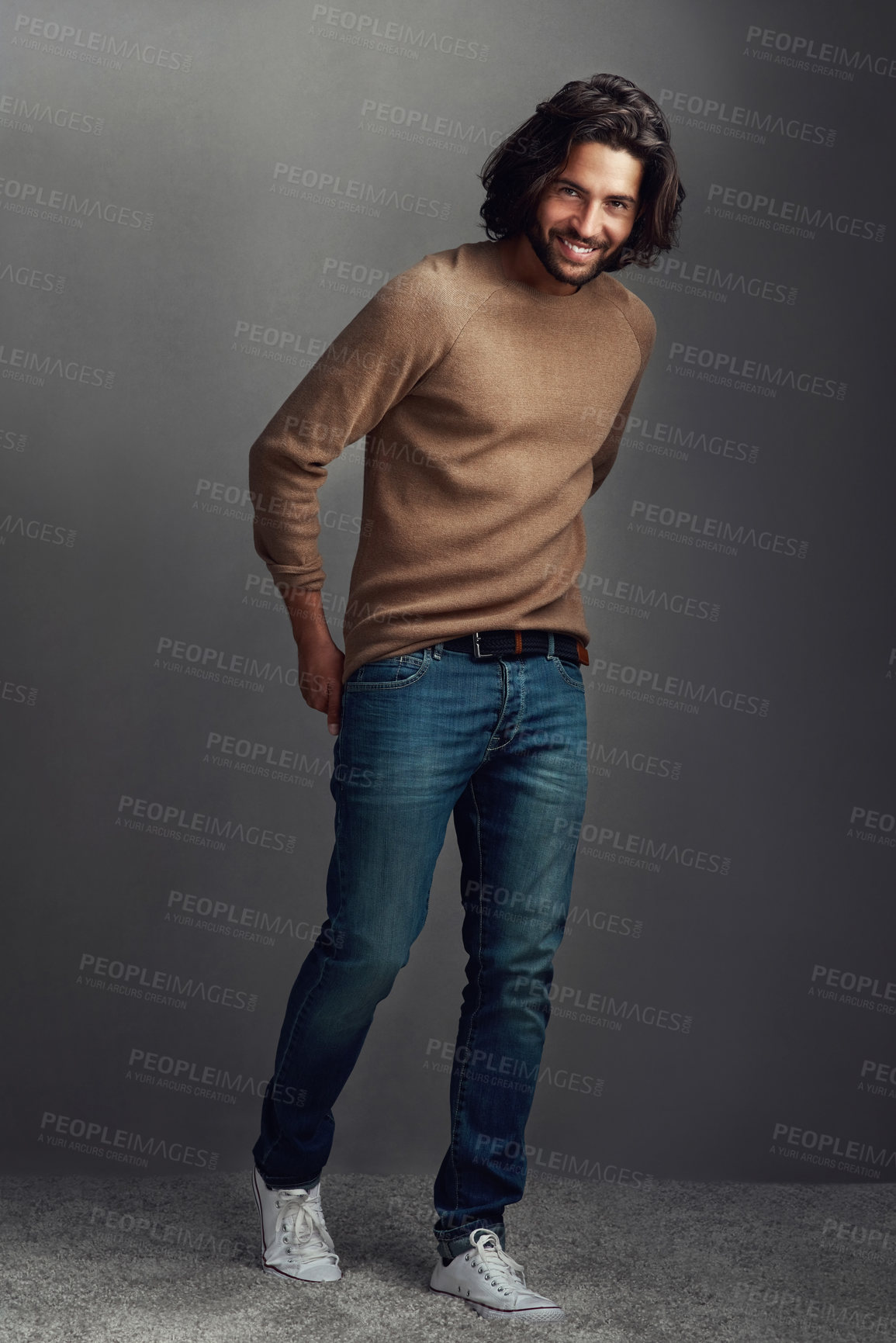 Buy stock photo Smile, man and portrait with fashion in studio for elegant, style and comfortable winter jeans clothes. Cool, male person and trendy jersey, designer wardrobe or hands in pocket on grey background