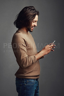 Buy stock photo Happy man, smartphone and profile in studio for reading, ebook and online or mobile app. Smile, person and social media or internet for connection and notification for blog or meme by dark background