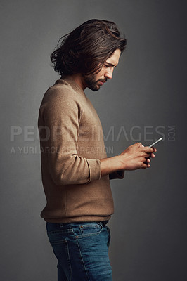 Buy stock photo Man, phone internet and communication with reading email, social media post and website for ebook download in studio. Guy, mobile and typing for online puzzle, text app and network by gray background