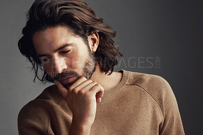 Buy stock photo Studio shot of a handsome young man looking thoughtful against a gray background