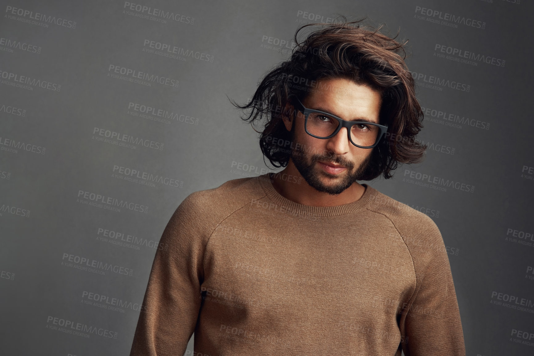 Buy stock photo Studio shot of a handsome young man posing against a gray background