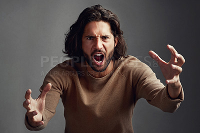 Buy stock photo Studio shot of a young man screaming in anger against a gray background