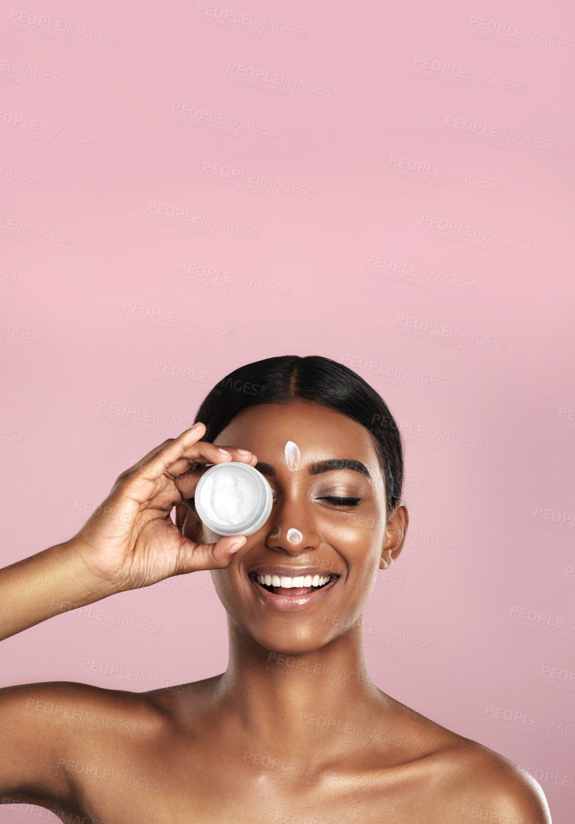 Buy stock photo Smile, skincare and woman with cream container in studio isolated on pink background mockup space. Eyes closed, creme cosmetics and Indian female model with lotion, moisturizer product or dermatology