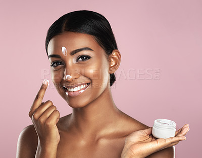 Buy stock photo Skincare, face and woman with cream container in studio isolated on a pink background. Product, dermatology creme and portrait of happy Indian female model apply lotion, moisturizer and cosmetics.