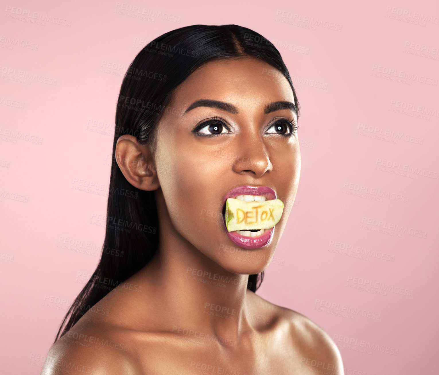 Buy stock photo Detox, fruit and woman with apple in her mouth for beauty empowerment isolated in a studio pink background. Skincare, food and female model or person on diet for self love or cosmetic care