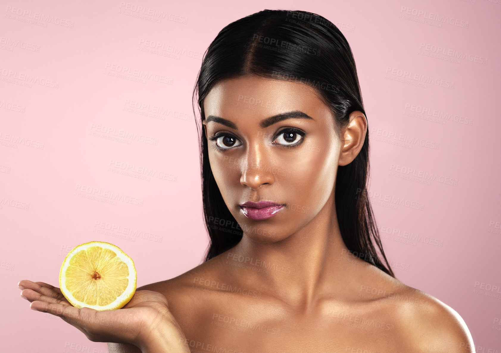 Buy stock photo Face, skincare and woman with lemon in studio isolated on pink background. Fruit, serious and portrait of Indian female model with citrus food for healthy skin, vitamin c and detox diet for nutrition