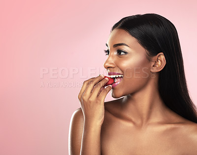 Buy stock photo Woman, glow or eating of fruit, nutrition or idea of wellness, health of self care on studio mockup. Indian girl, strawberry or smile at planning, weight loss or antioxidant, detox or pink background