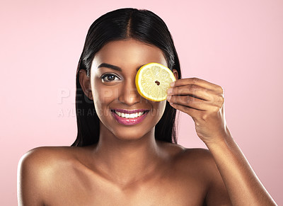 Buy stock photo Face, skincare and smile of woman with a lemon slice in studio isolated on a pink background. Fruit, natural cosmetics and portrait of Indian female model with food for detox, nutrition and vitamin c