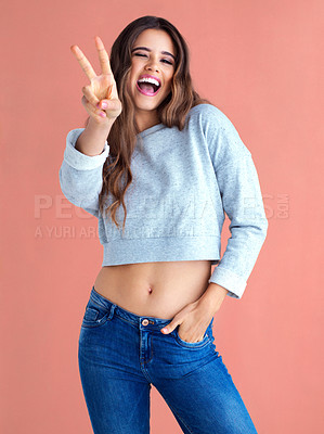 Buy stock photo Woman, peace sign and smile in studio portrait with laugh, excited and fashion by background. Girl, person and model with style, clothes or streetwear with icon, symbol or emoji with hand in pocket