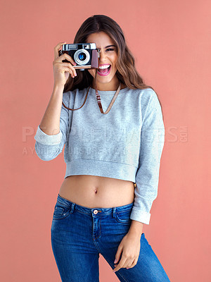 Buy stock photo Studio shot of a beautiful young woman posing with a vintage camera against a pink background